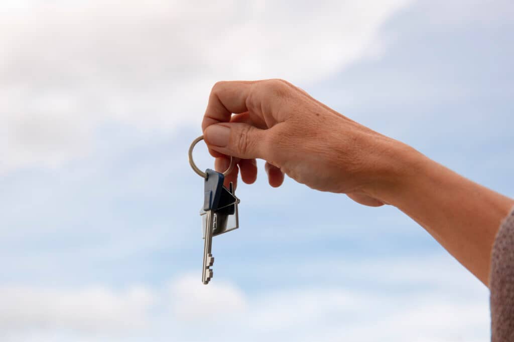 Main tenant un trousseau de clés, symbolisant le concept de cabinet médical clé en main proposé par le Cabinet Pluridisciplinaire de la Pelouse à Montgeron, disponible en location longue durée pour les professionnels de santé.