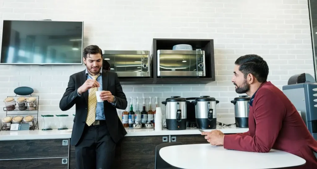 Deux professionnels de santé profitant de la salle de pause du Cabinet Pluridisciplinaire de la Pelouse à Montgeron, un espace convivial avec réfrigérateur, micro-ondes et machine à café pour les praticiens.